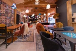 The interior of a restaurant with colorful chairs and tables.