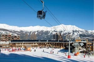 Marmotel & Spa - A ski resort with a ski lift and snowy mountains in the background.