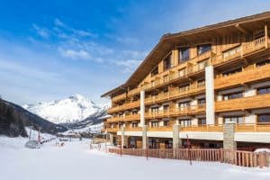A ski resort with a wooden building in the snow.